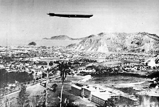 O 'Graf Zeppelin' sobrevoando Santos, tendo em primeiro plano o hospital da Santa Casa (clique na imagem para obter detalhes e créditos)